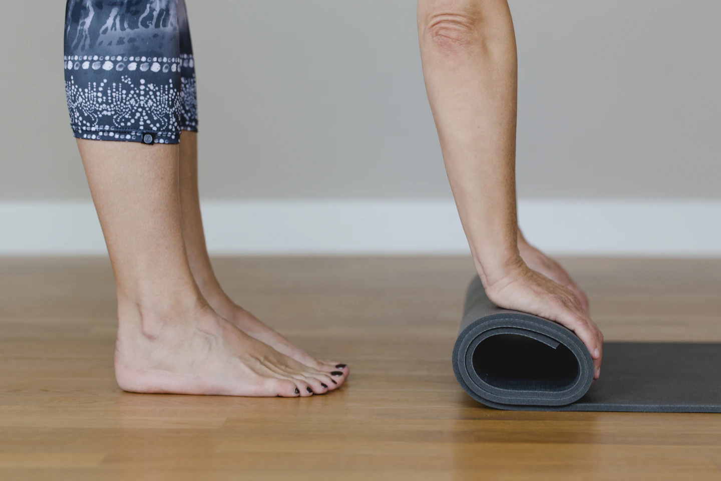 Detalle de pies al recoger un tapete de yoga